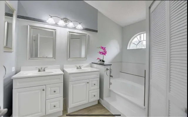 a bathroom with a tub sink and mirror