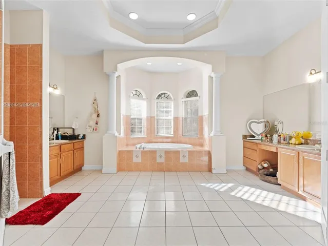 a large spacious bathroom with a tub sink and mirror