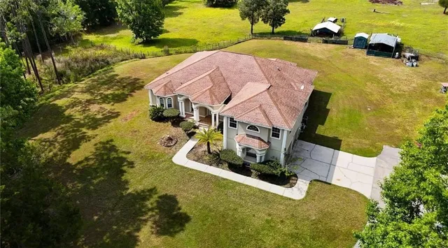 an aerial view of a house with a yard basket ball court and outdoor seating