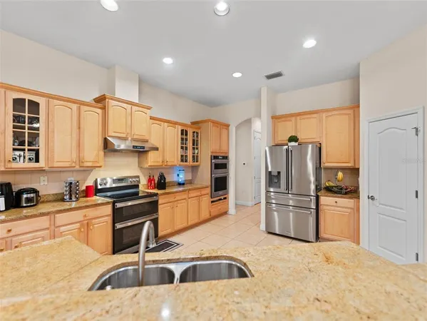 a kitchen with granite countertop a refrigerator and a sink