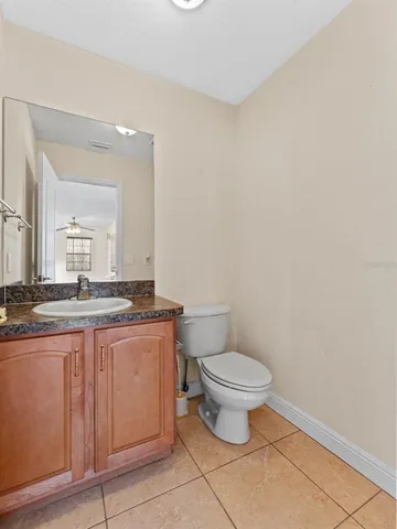 a bathroom with a granite countertop toilet a sink and a mirror
