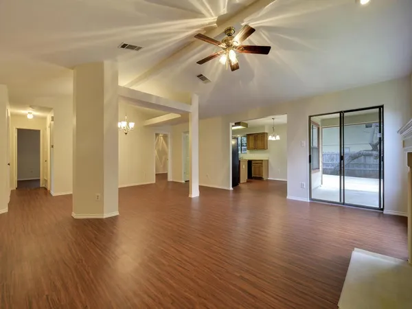 a view of a big room with wooden floor a ceiling fan