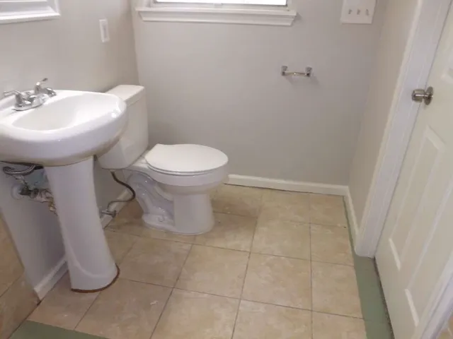 a bathroom with a sink toilet and a mirror