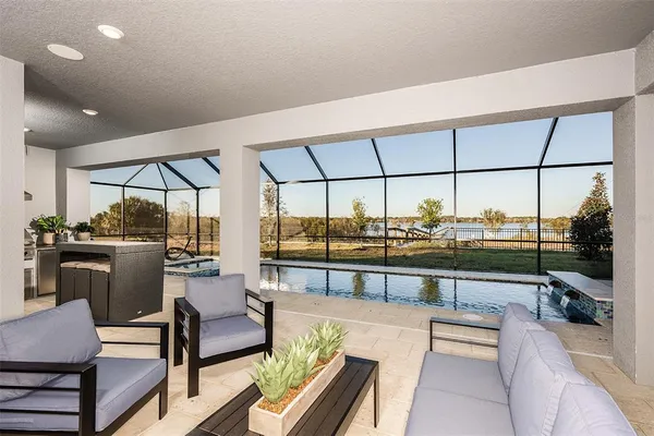 a living room with furniture a flat screen tv and a floor to ceiling window