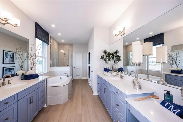 a large bathroom with a double vanity sink a large mirror and a bathtub