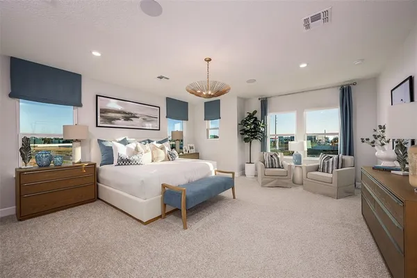 a spacious bedroom with bed and a chandelier