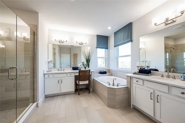 a large bathroom with a double vanity sink a large mirror and a bathtub