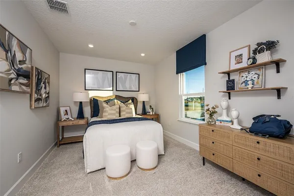 a spacious bedroom with a bed and a cabinets