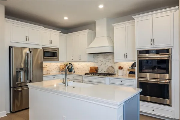 a kitchen with stainless steel appliances a sink stove and refrigerator