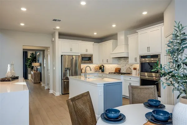 a kitchen with stainless steel appliances granite countertop sink stove refrigerator and cabinets