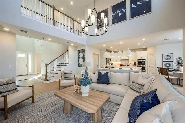 a living room with furniture kitchen view and a chandelier