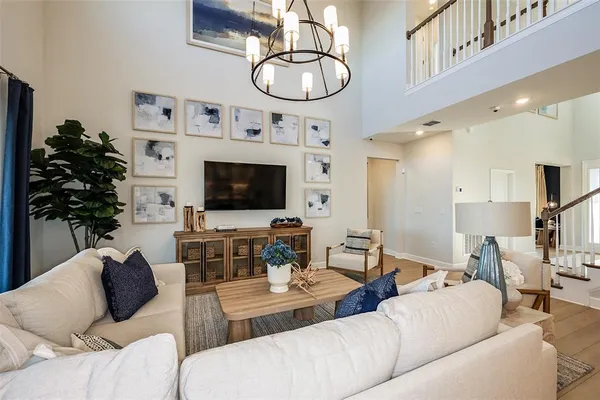 a living room with furniture a flat screen tv and kitchen view