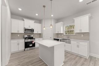 636 Bald Ridge Circle Demorest, GA 30535 - Photo 7 of 35 a kitchen with stainless steel appliances kitchen island a sink a stove a refrigerator and white cabinets
