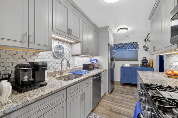 a kitchen with stainless steel appliances granite countertop a sink stove and refrigerator