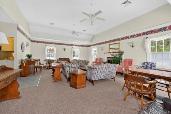a living room with lots of white furniture and a large window