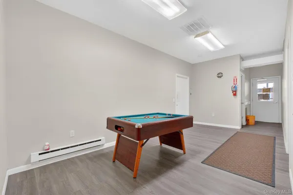 a room with wooden floor and pool table