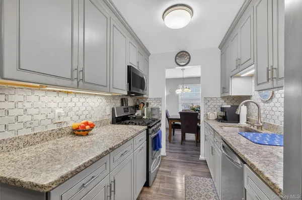 a kitchen with stainless steel appliances granite countertop a sink stove and refrigerator