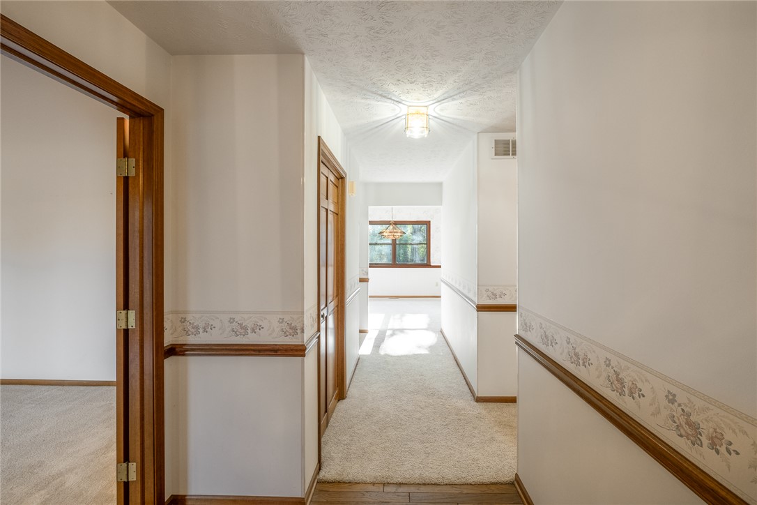 276 South Fairfield Road Bellbrook, OH 45305 - Photo 5 of 38 This welcoming hallway features neutral tones, a blend of carpet and hardwood flooring, and a luminous window vista.