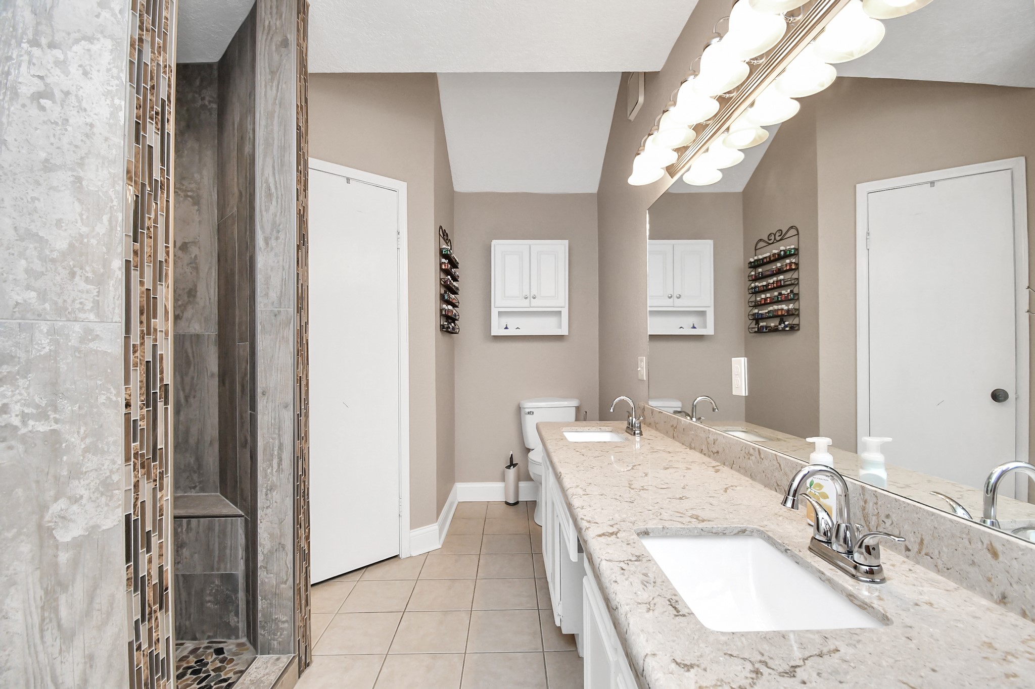 20202 Deer Run Road Damon, TX 77430 - Photo 14 of 45 a bathroom with a granite countertop sink a mirror and a shower