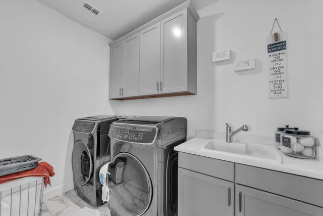 a utility room with sink dryer and washer