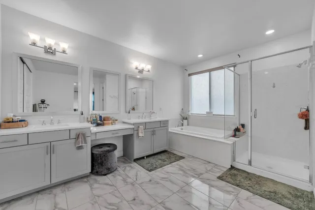 a bathroom with a double vanity sink a mirror and a bathtub