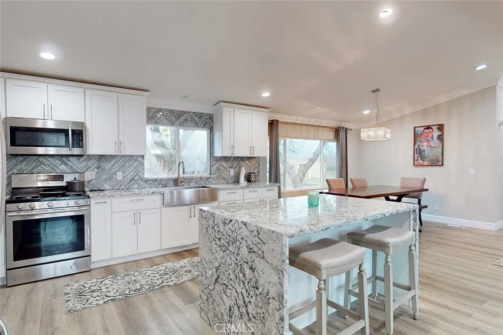 3453 La Porte Road Oroville, CA 95966 - Photo 16 of 69 a kitchen with stainless steel appliances granite countertop a stove a sink a microwave a dining table and chairs