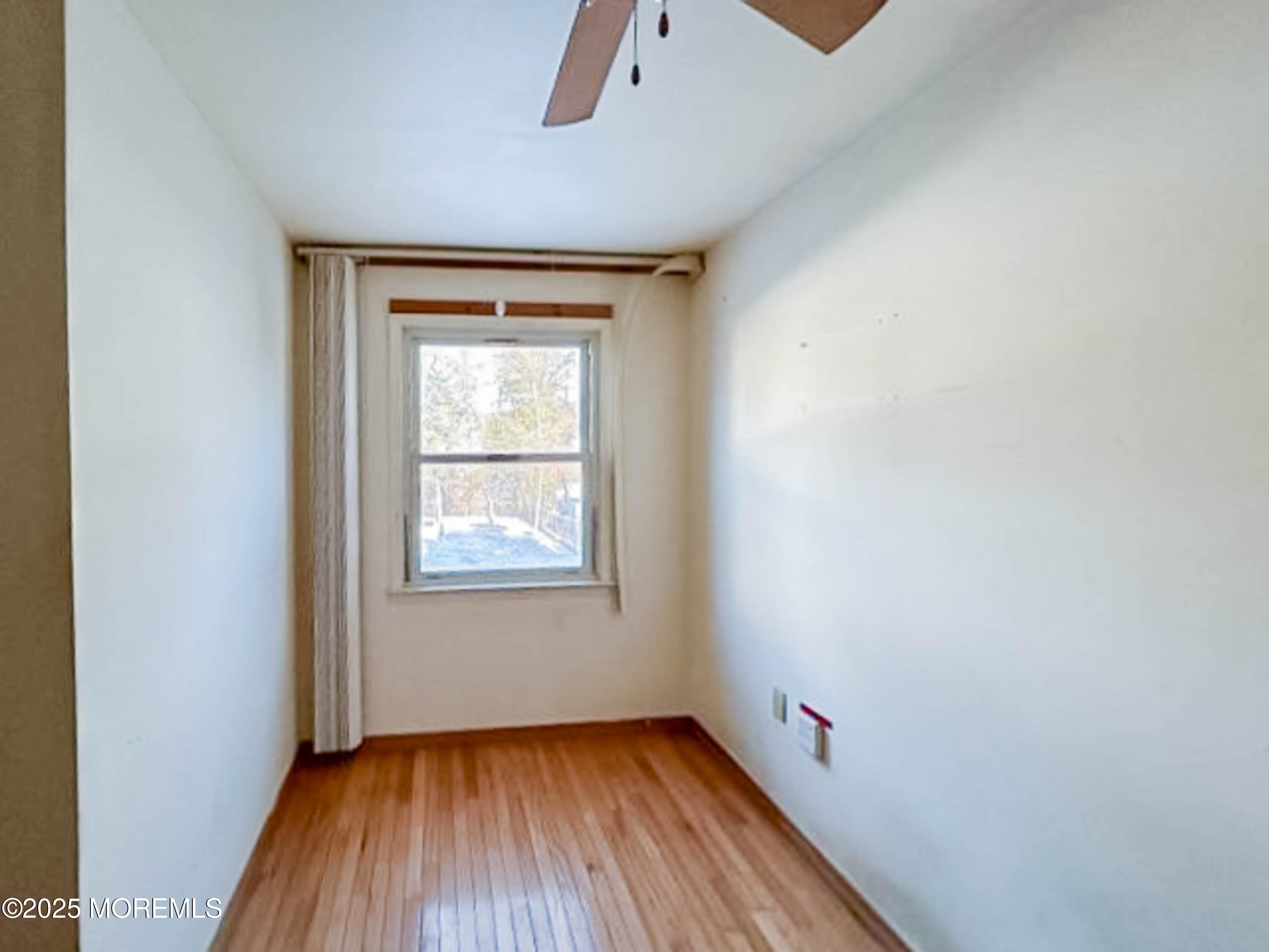 58 Manalapan Road Spotswood, NJ 08884 - Photo 11 of 22 an empty room with wooden floor and windows