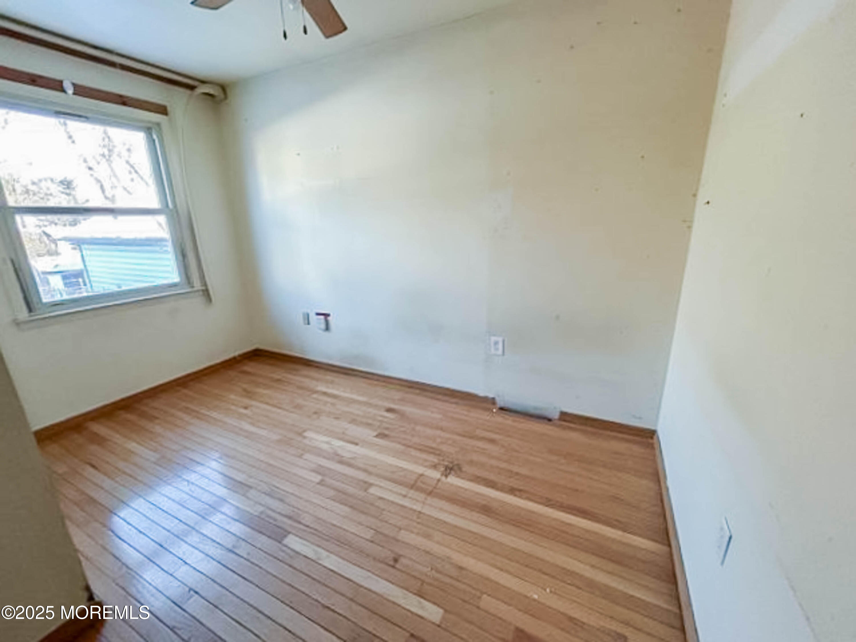 58 Manalapan Road Spotswood, NJ 08884 - Photo 10 of 22 an empty room with wooden floor and windows