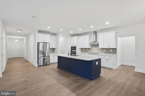 a kitchen with stainless steel appliances kitchen island granite countertop a refrigerator and a stove top oven