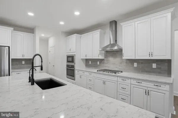 a kitchen with stainless steel appliances kitchen island a white sink and cabinets