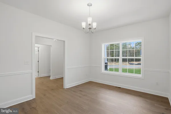 an empty room with a windows and chandelier