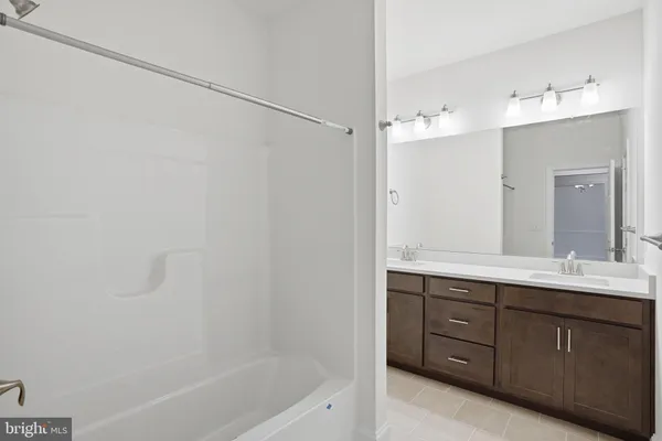 a bathroom with a tub sink and mirror