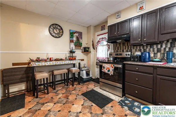 a kitchen with a refrigerator and a stove top oven