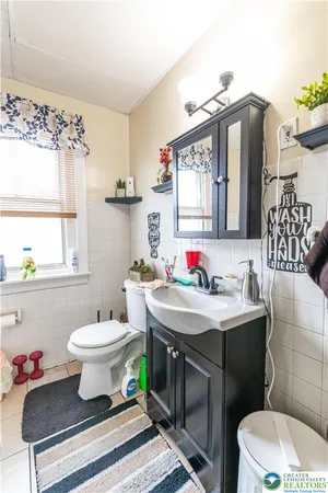 a bathroom with a sink toilet and a mirror