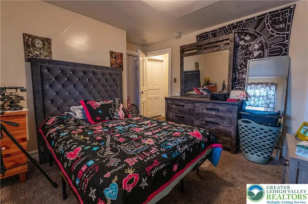 a bedroom with a bed window and dresser