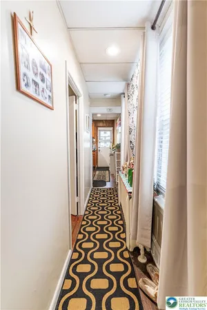 a walk in closet with wooden floor