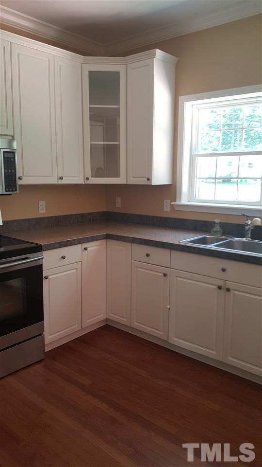 304 Dirgie Mine Road Roxboro, NC 27574 - Photo 3 of 25 a kitchen with granite countertop white cabinets and a wooden floor