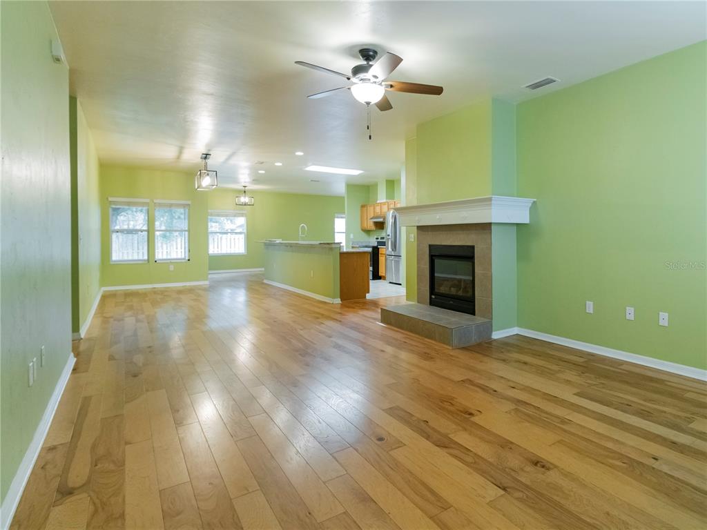 8436 Southwest 77th Avenue Gainesville, FL 32608 - Photo 3 of 21 an empty room with a fireplace and fan