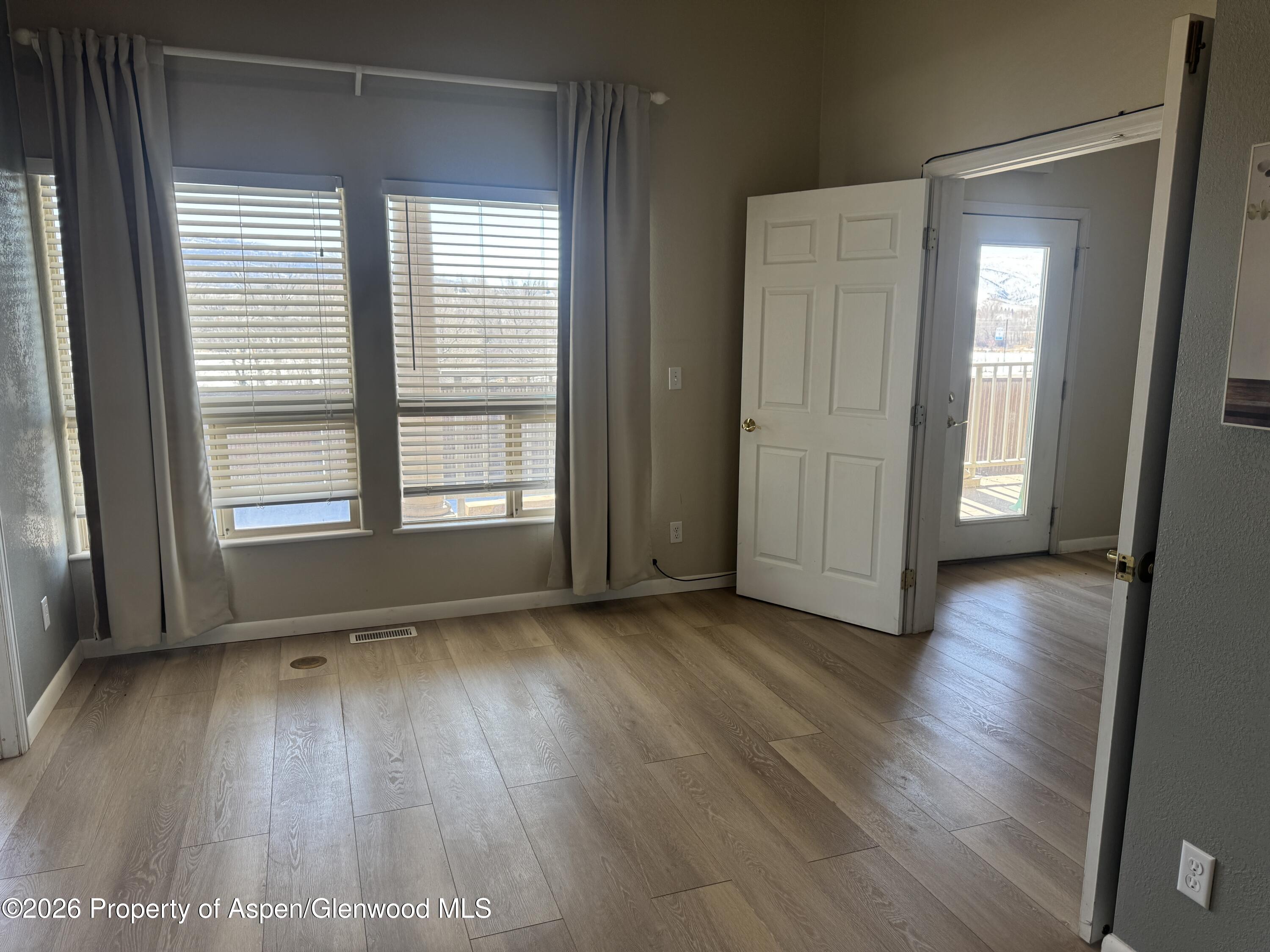 1287 Market Street Meeker, CO 81641 - Photo 7 of 42 an empty room with wooden floor and windows