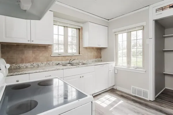 a kitchen with granite countertop white cabinets and white appliances