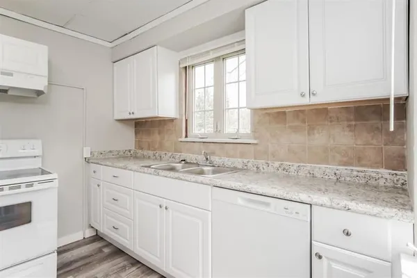 a kitchen with granite countertop white cabinets and white appliances