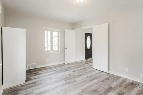 an empty room with wooden floor and a window