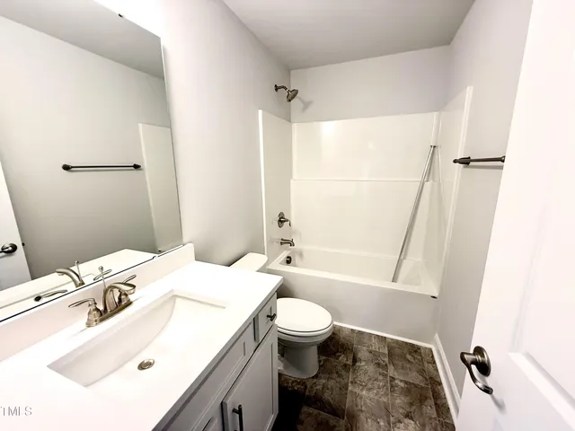 a bathroom with a sink toilet vanity and shower