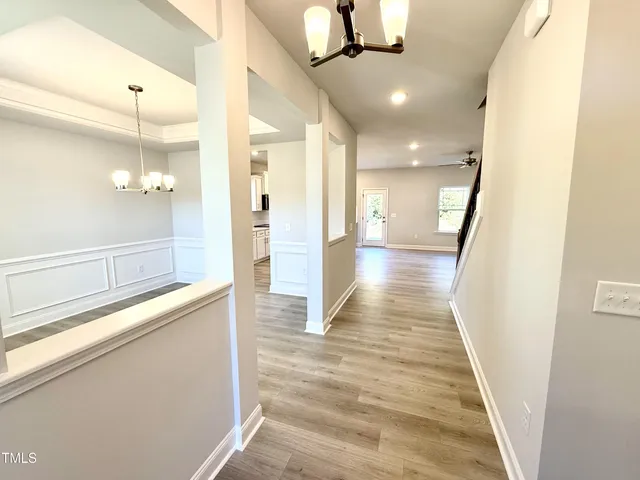 a view of a hallway with wooden floor and staircase