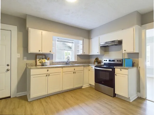 a kitchen with stainless steel appliances granite countertop a stove a sink and a refrigerator