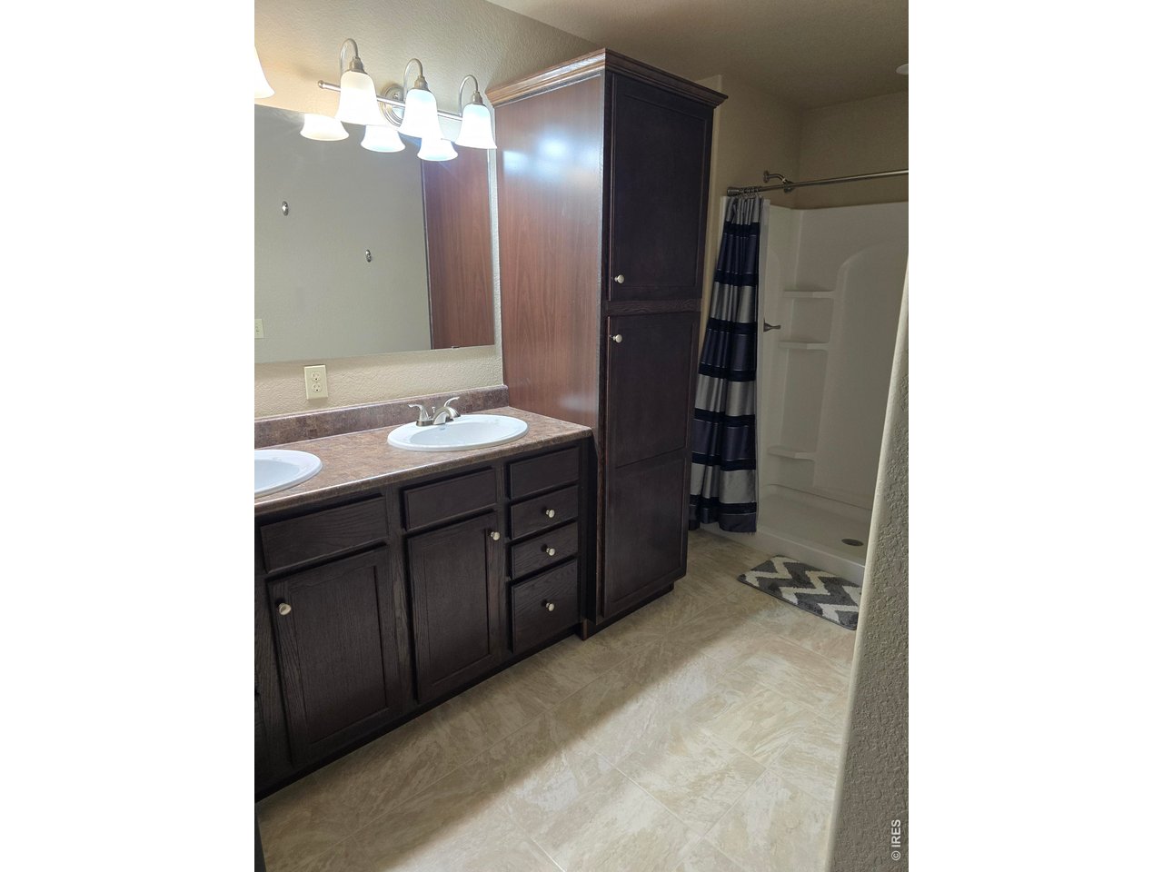 14846 Bluestem Street Sterling, CO 80751 - Photo 18 of 28 a bathroom with a double vanity sink and a mirror