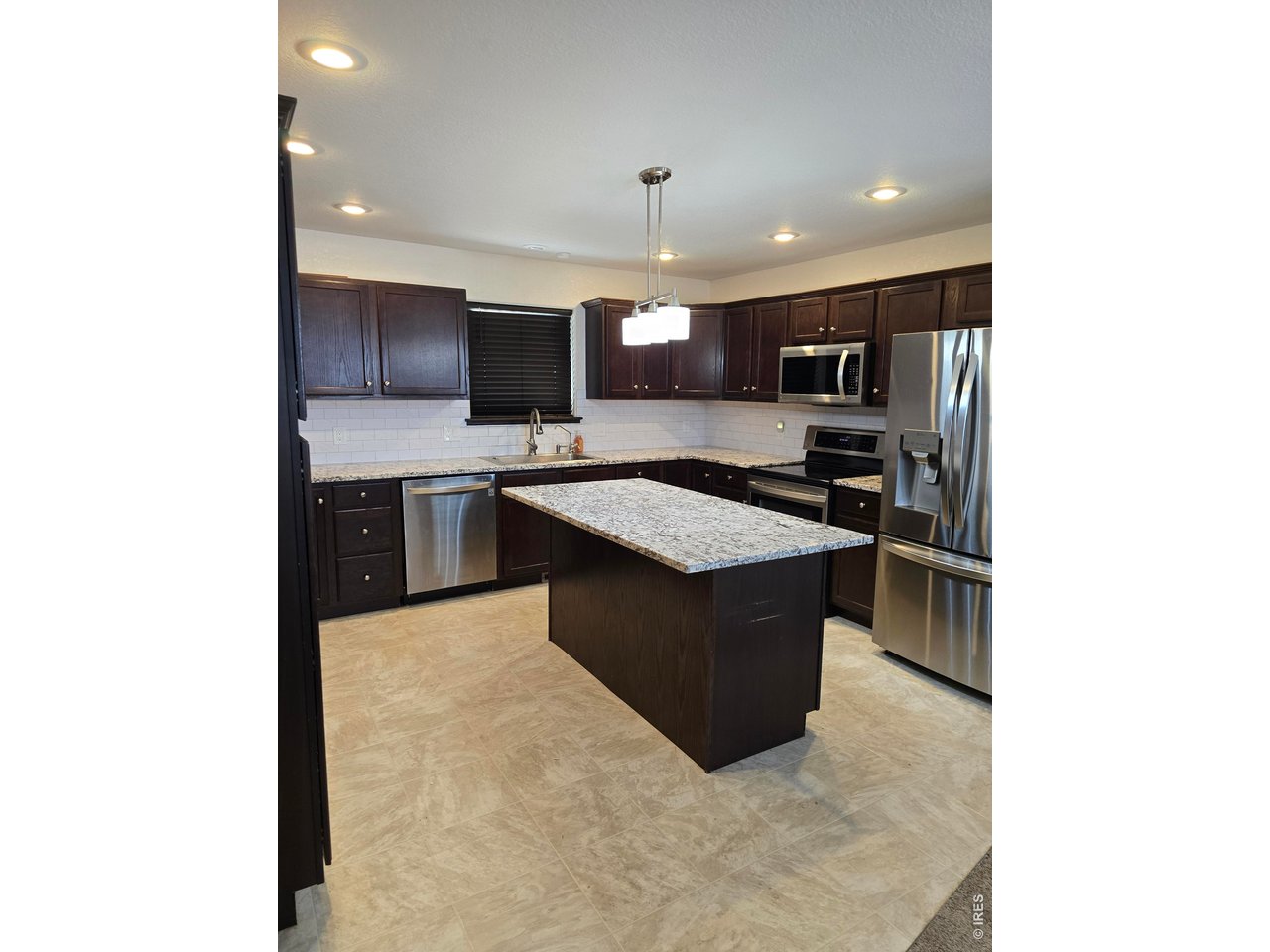 14846 Bluestem Street Sterling, CO 80751 - Photo 2 of 28 a kitchen with stainless steel appliances granite countertop a sink and a stove