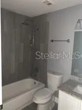 a white toilet sitting next to a bath tub and a shower