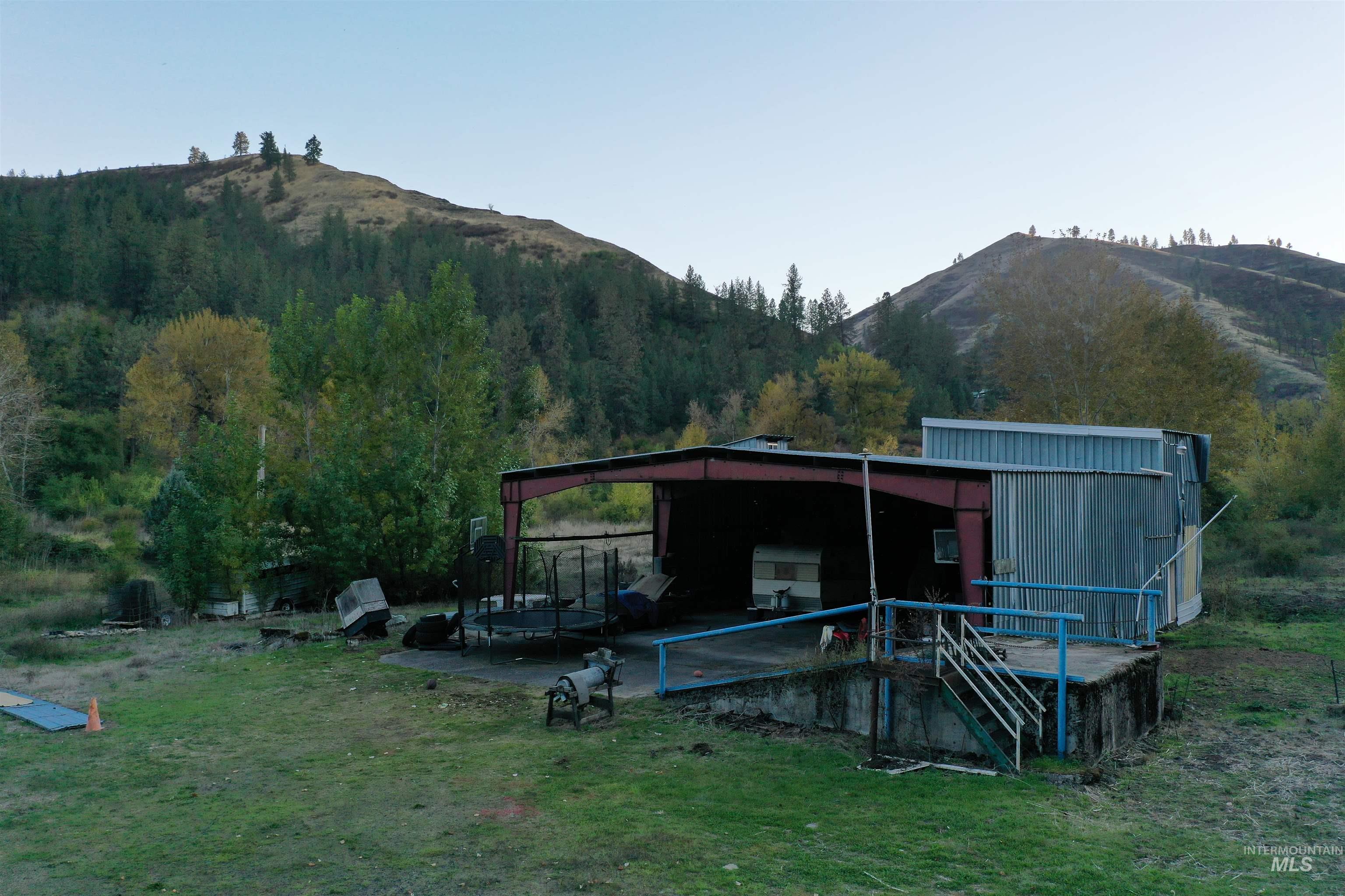 3210 Highway 162 Kamiah, ID 83536 - Photo 3 of 28 Back of house with a mountain view, an outbuilding, and a yard