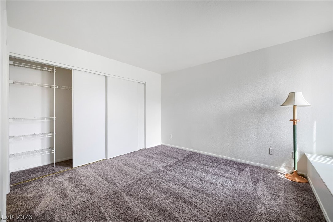 9325 West Desert Inn Road, Unit 177 Las Vegas, NV 89117 - Photo 12 of 24 A well-lit bedroom features plush carpeting and convenient closet storage.